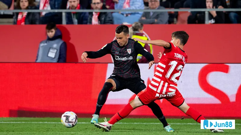 นักเตะของ Athletic Bilbao และ Girona กำลังแย่งบอลบนสนามหญ้า